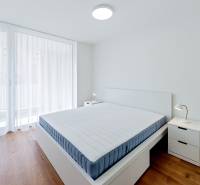 Svetlá spálňa s posteľou a nočným stolíkom v 2-izbovom byte na ulici Floriánska.