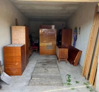 A garage on Veterná Street in Holíč with stored antique furniture and wooden panels.