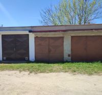 Garages on Veterná Street in Holíč with metal doors and a lawn.