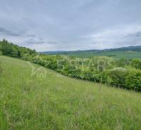 A meadow surrounded by forest and hills on the Recreational grounds in Kostolná-Záriečie.