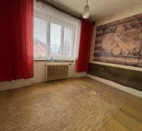 A room with an antique map on the wall and red curtains in a 4-room apartment.