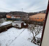 A snowy garden with trees and an annex in Zamarovce, Trenčín, behind a 4-room apartment.