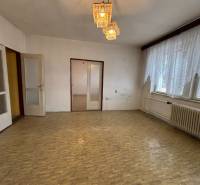 A room in a 4-room apartment with a parquet floor and a large window with a radiator.