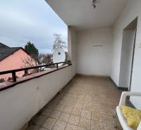 A balcony in a 4-room apartment with a satellite dish and a chair on the terrace.