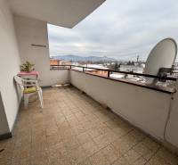 The balcony of a 4-room apartment in Zamarovce, Trenčín. A view of the snow-covered city and hills.