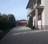 A family house on Kláštorská Street in Nitra with a paved courtyard next to a landscaped garden.