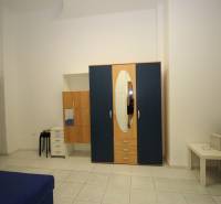 Bright 1-room apartment with a blue sofa and a large wardrobe with an oval mirror.