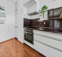 A kitchen with white cabinets and a dark countertop in a 2-room apartment.