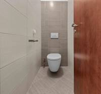 A bathroom with tiled walls in a 2-room apartment.