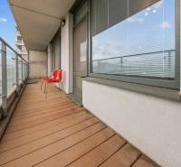 A balcony with two red chairs at a 2-room apartment on Nevädzova Street, Bratislava - Ružinov.