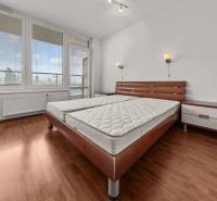Stylish bedroom with a large bed in a 2-room apartment with parquet flooring.