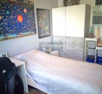 One of the rooms in a 3-room apartment contains a bed, a wardrobe, and decorative posters.