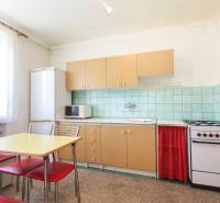 Kitchen in a 3-room apartment with a table, chairs, and a kitchen unit.