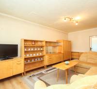 Living room in a three-room apartment equipped with a sofa set, retro furniture, and a television.
