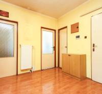 A hallway in a 3-room apartment with laminate flooring, doors, and a radiator.