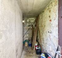 A narrow storage space in a 3-room apartment with tools and buckets.