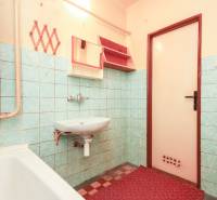 A bathroom with a sink and a bathtub in a 3-room apartment, tiled with blue tiles.