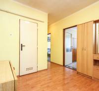Hallway of a 3-room apartment with flooring and wooden furniture in light tones.