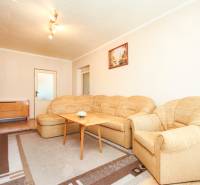 Living room with a beige sofa and wooden furniture in a 3-room apartment.
