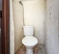 A toilet with simple tiles in a 3-room apartment.