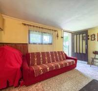 Living room with a red sofa, shelves, and light-colored walls in a 3-room apartment.