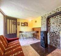 A room with a fireplace in a 3-room apartment, rustic furniture and a patterned carpet.