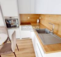 A kitchen with a wooden countertop and dining table in a 2-room apartment.