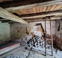 Old walls, wooden ceiling, and building material in a family house.
