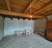 A room in a family house with a wooden ceiling, brick walls, and old furniture.