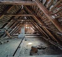 The attic of a family house with an old wooden beam roof structure and a pitched roof.