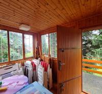 Wooden garden room with large windows and stacked furniture in the construction of houses.