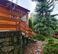 A wooden house with a garden and a stone path in Tavarikova Settlement in Bratislava - Dúbravka. Construction of houses.