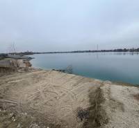 A lake surrounded by a sandy shore, on Veľké Košariská Street, Recreational plots.