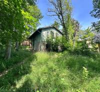 A cottage in a natural setting on Harmónia Street in Modra, surrounded by greenery and trees.