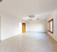 A spacious room with tiles and a window in a family house, bright walls.
