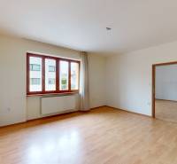 An empty room in a family house with laminate flooring and a wooden window.