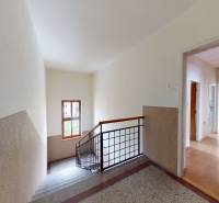 Staircase and hallway in a family house with wooden doors and railing.