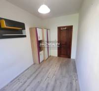 A small room with a wooden floor, a wardrobe, and original wall decoration in a 4-room apartment.