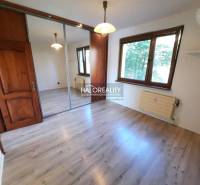 A room in a 4-room apartment with a wooden floor, a mirrored wardrobe, and a window.