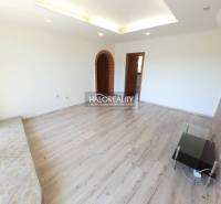 Living room in a 4-room apartment with wooden flooring and a brick arch.