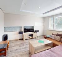 Living room in a 3-room apartment with a couch, coffee table, and television on a low cabinet.