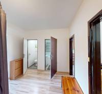 Interior of a 3-room apartment with wooden flooring, furniture, and access to a bathroom.