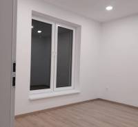 Empty room with a window, white walls, and wooden floor on Adyho Street.