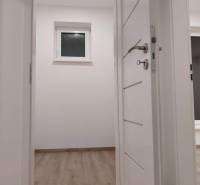 Interior with white doors, a window on Ady Street, a family house with wooden flooring.