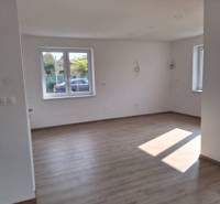 Spacious interior on Ady Street in a family house with wooden flooring and windows.
