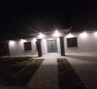 On Ady's Street, there is a family house with lights illuminating the entrance.