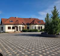 A family house on Dolnočermánska Street in Nitra with a large paved area and trees.