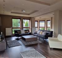 A spacious living area with comfortable sofas and wooden flooring in a family house.