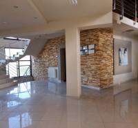 Interior of a family house with ceramic tiles, stone cladding, and a modern staircase.