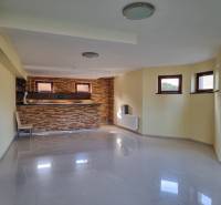 Open space with a bar counter and windows in a family house, light walls and floors.